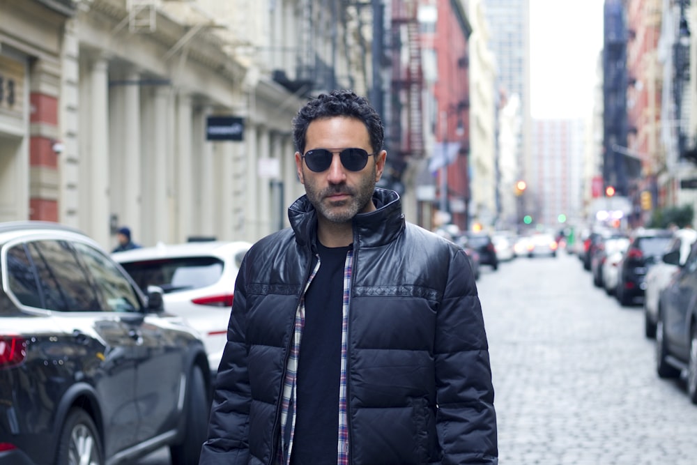 man in black leather jacket wearing black sunglasses