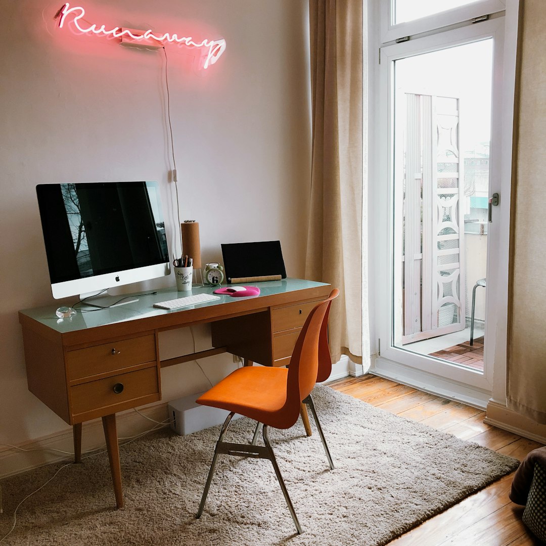 black flat screen computer monitor on brown wooden desk