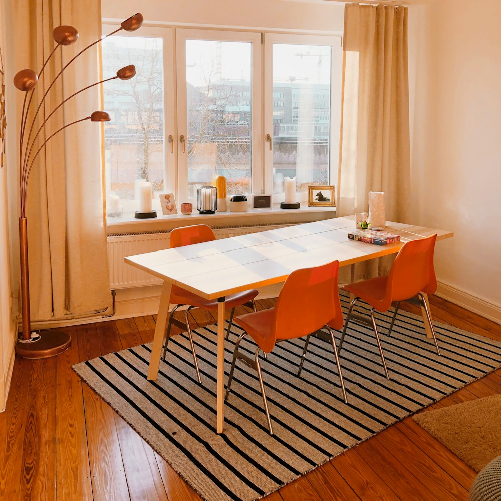 white wooden table with chairs near window