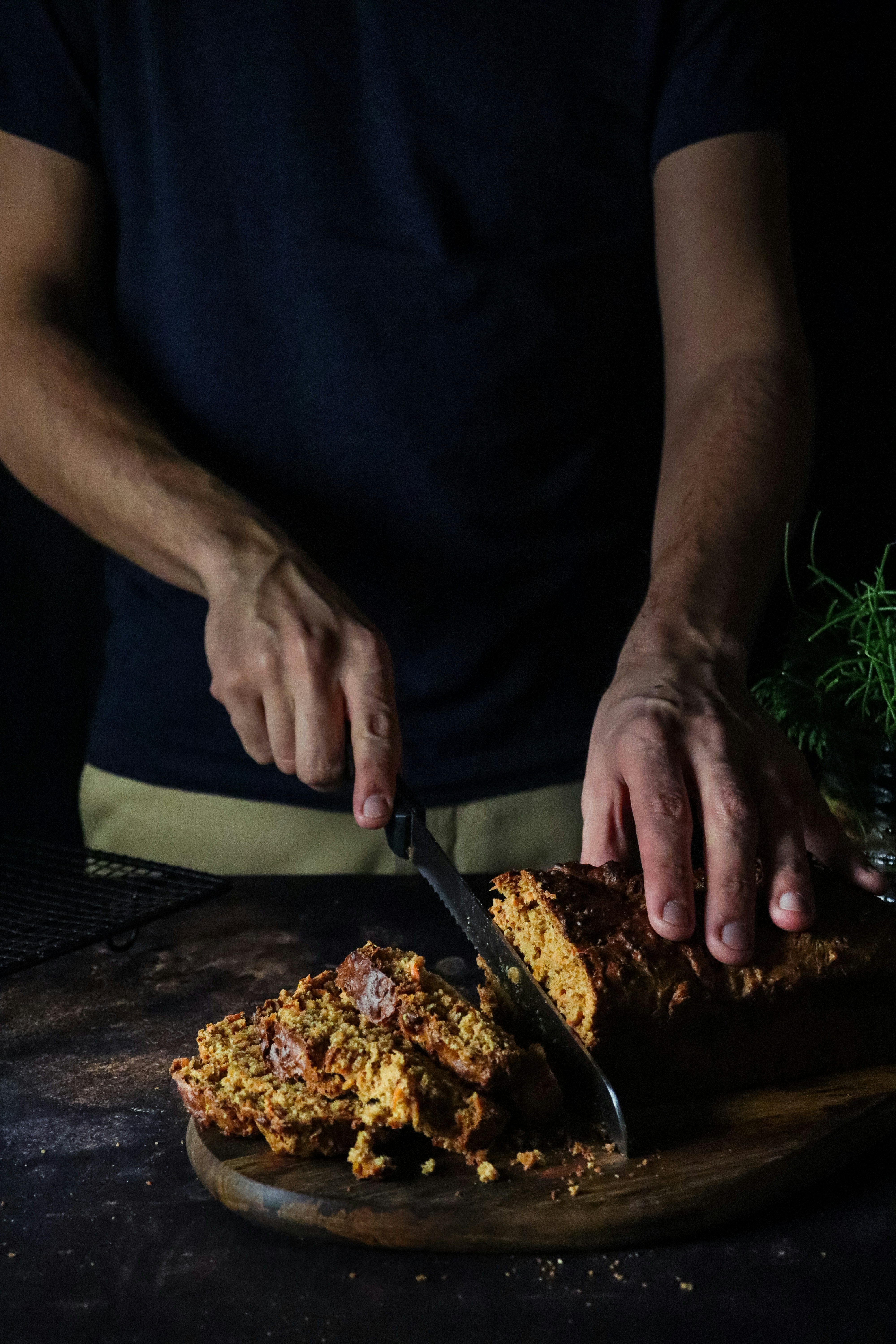 person in black shirt holding a brown pastry