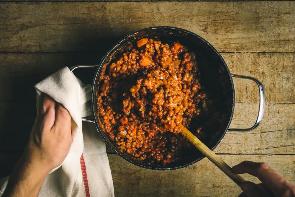 person holding stainless steel round tray with food