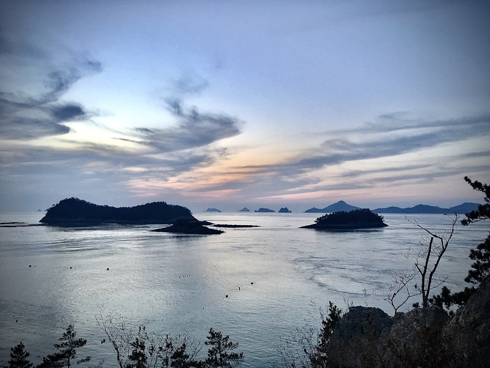 body of water near mountain during sunset