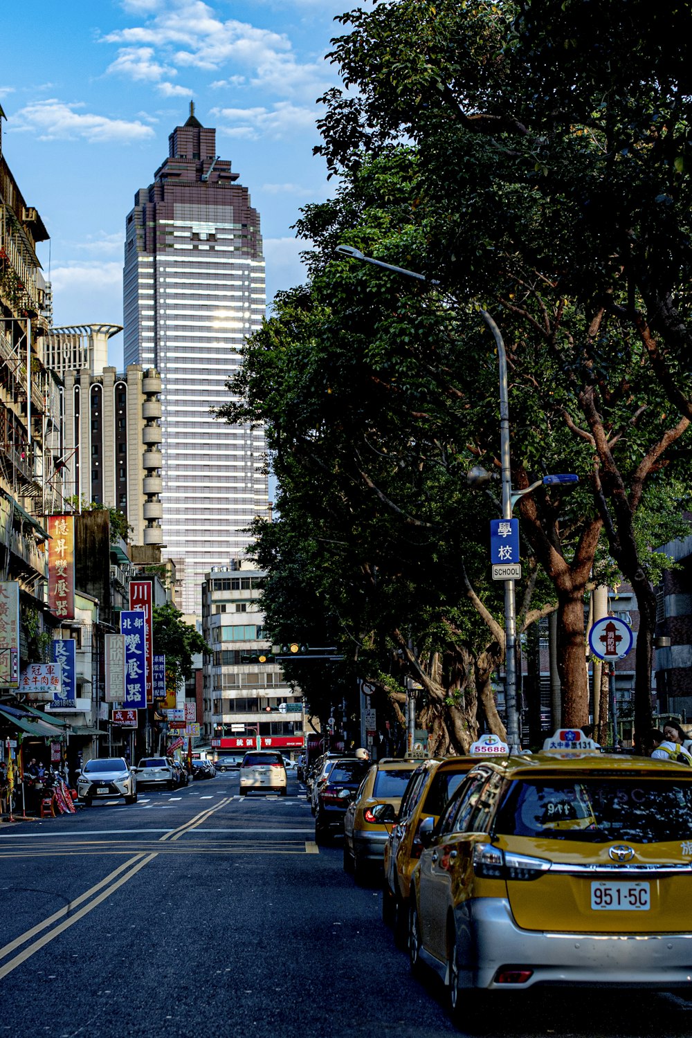 cars on road near high rise buildings during daytime