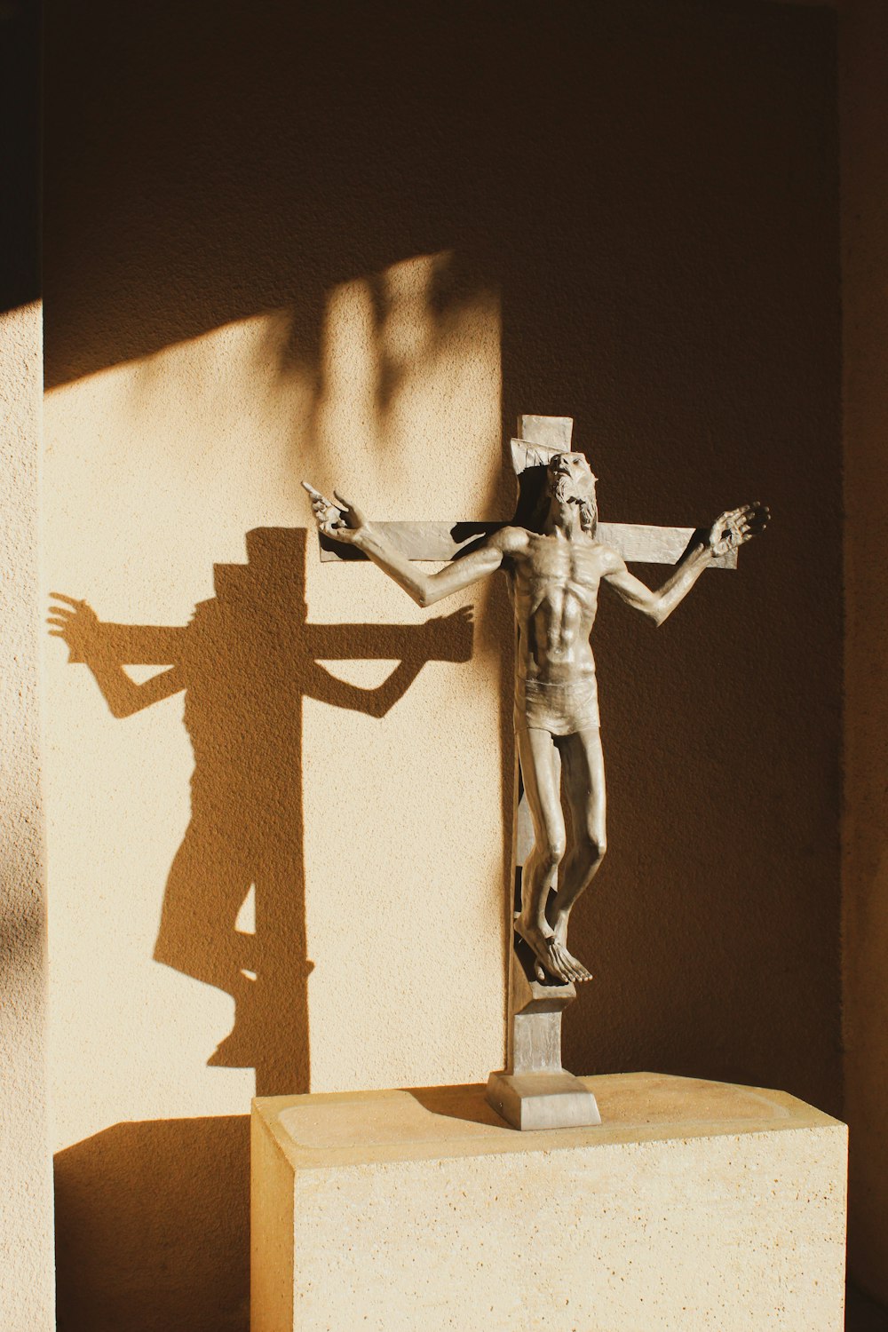 a statue of a man on a cross next to a building