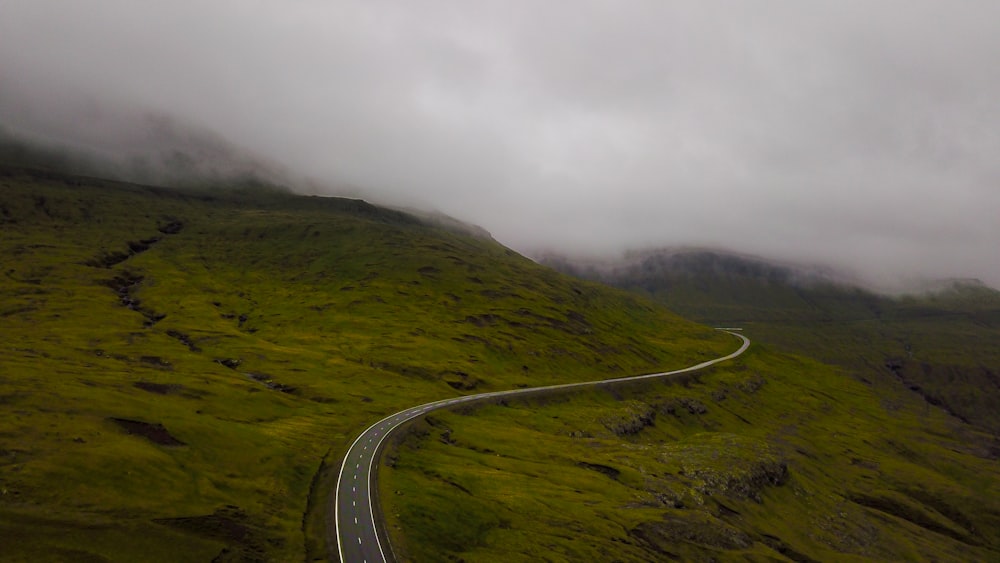 Carretera de asfalto gris en montaña verde