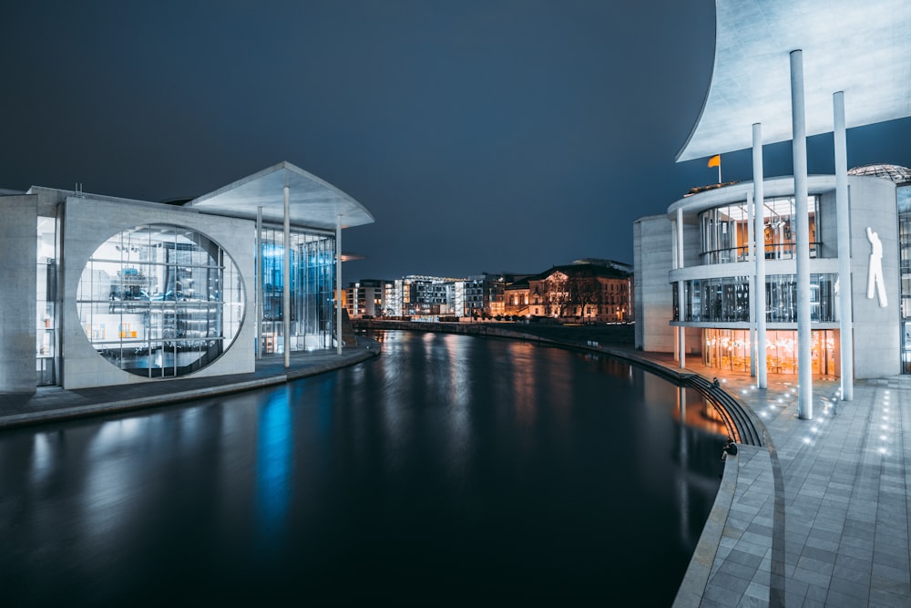 white and brown concrete building near body of water during night time