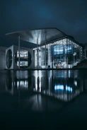 clear glass building near body of water during night time