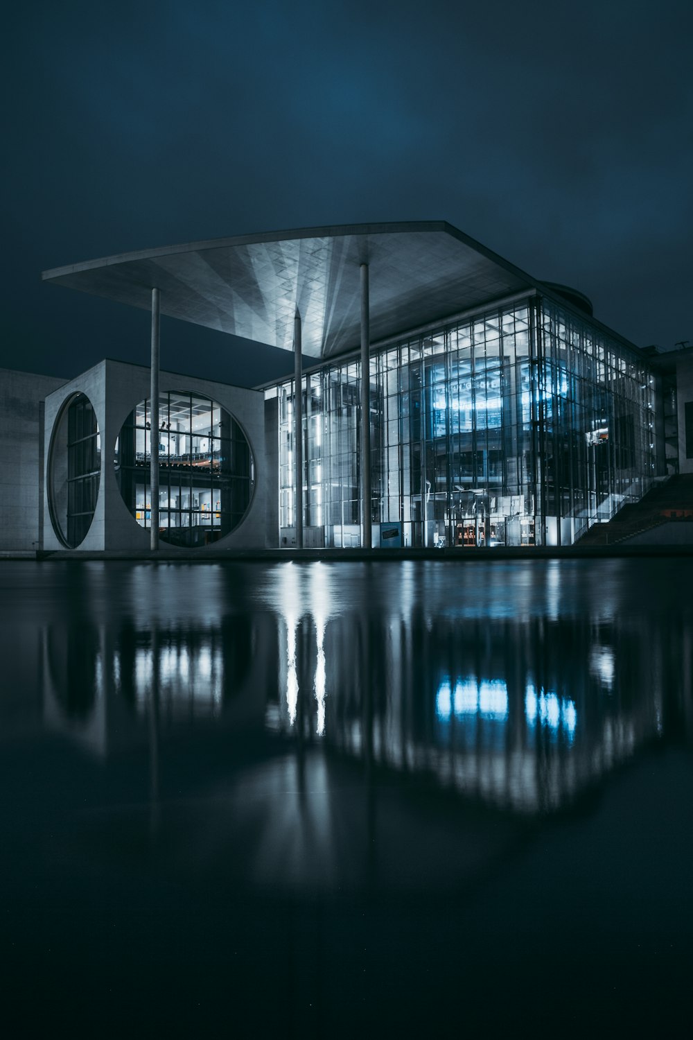 clear glass building near body of water during night time