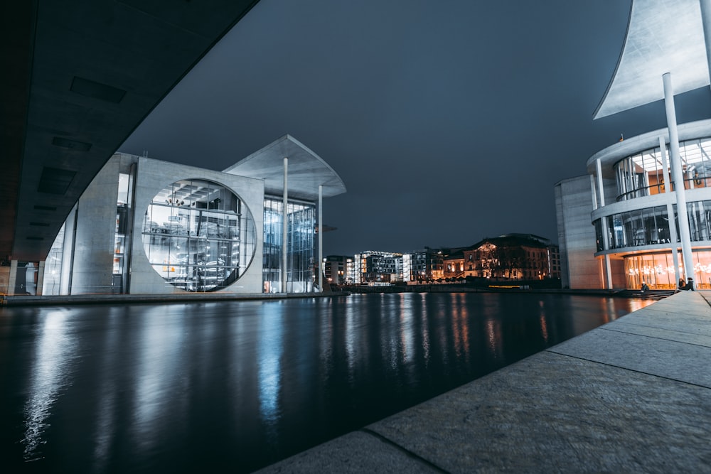 clear glass building near body of water during night time