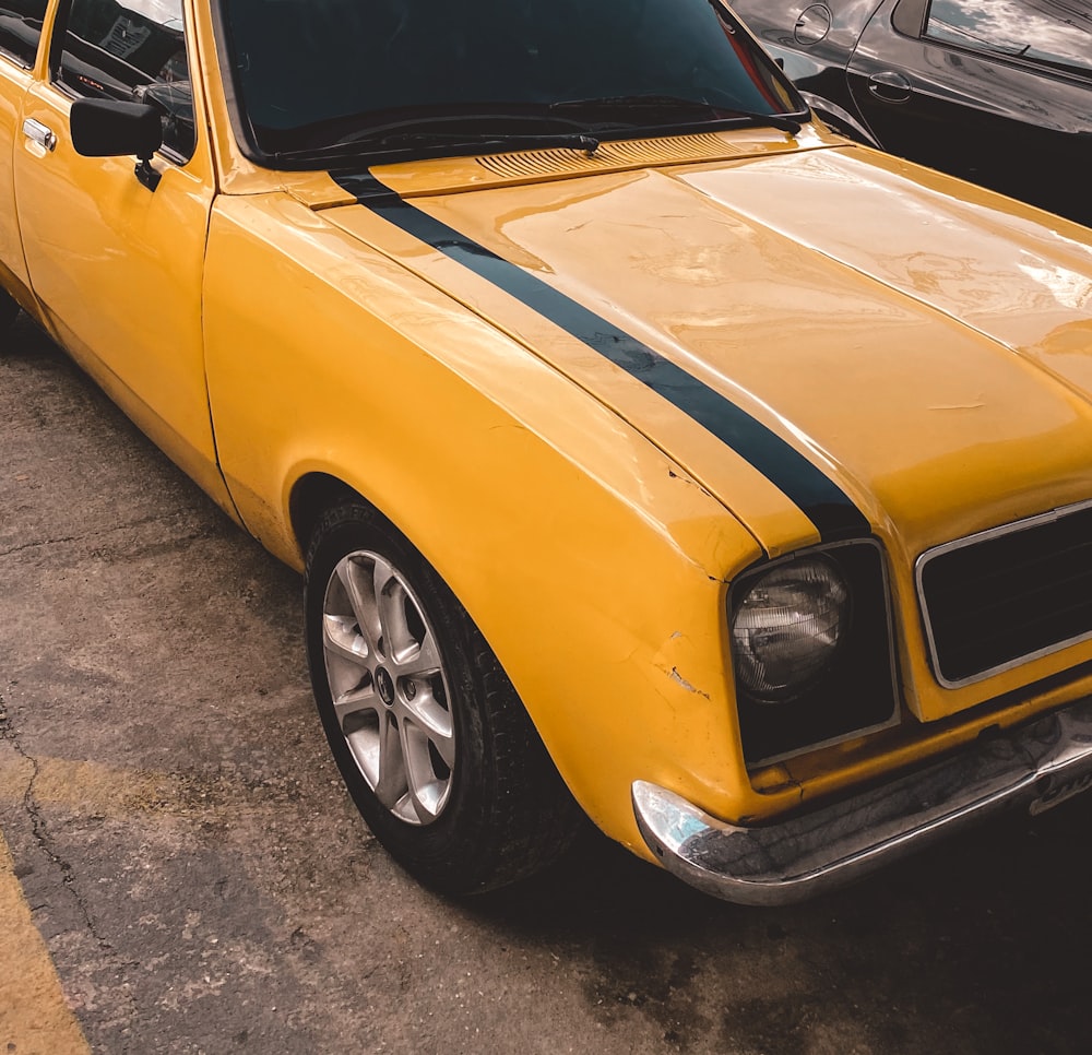 yellow car on gray asphalt road