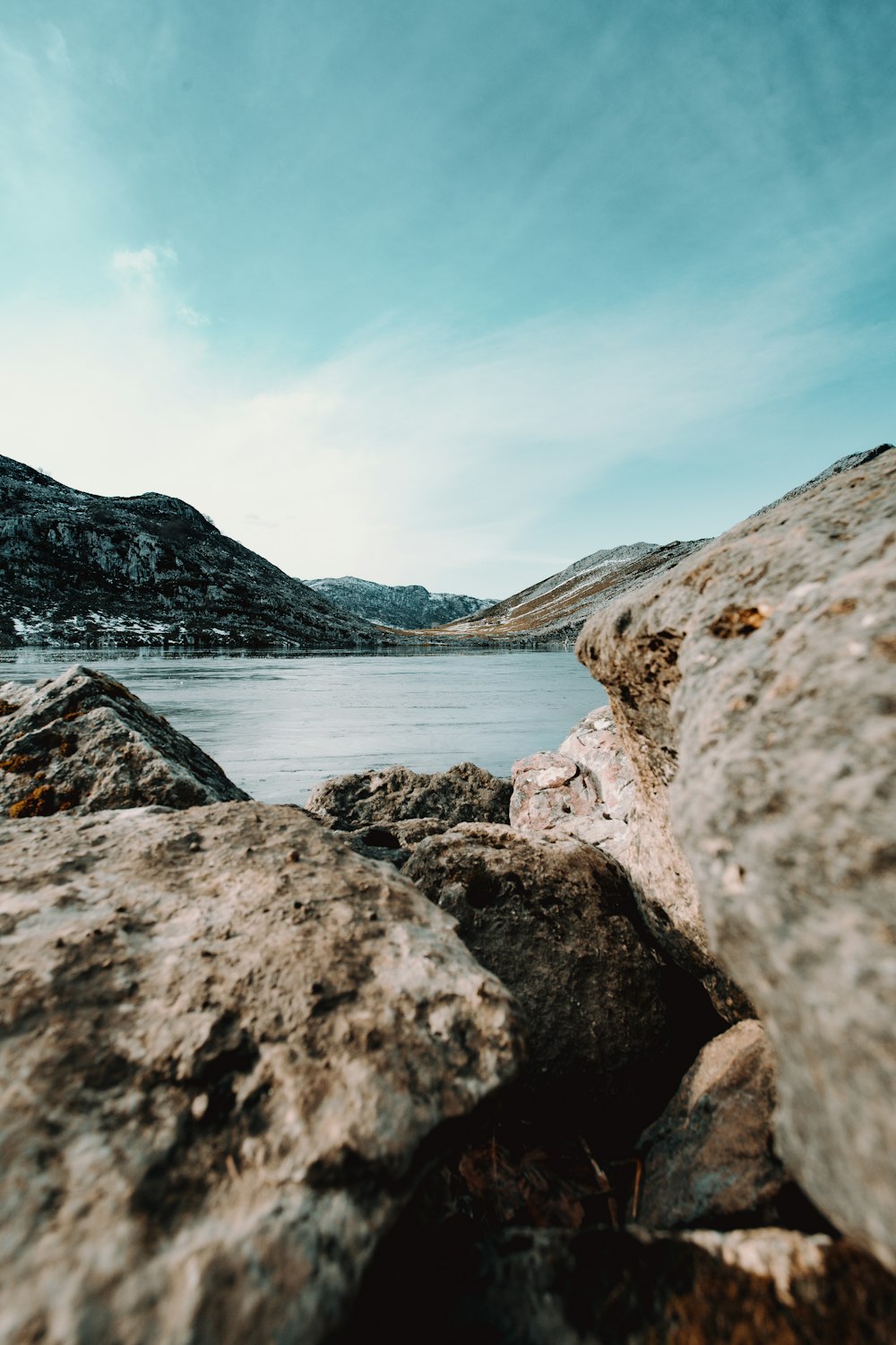 rocky shore near mountain under blue sky during daytime