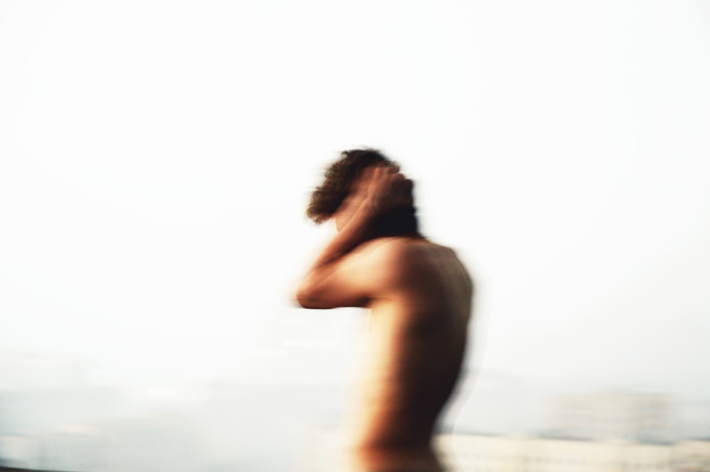 femme aux seins nus debout sur la plage pendant la journée