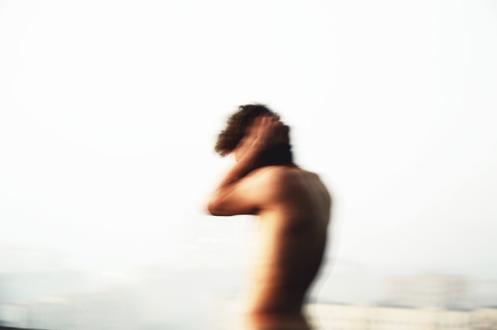 topless woman standing on beach during daytime