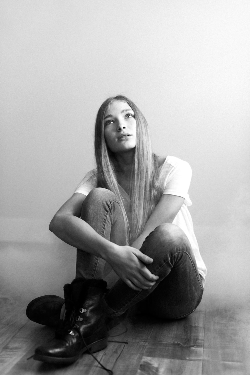 woman in white shirt and black pants sitting on the floor