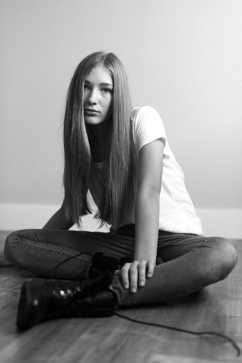 woman in white t-shirt and black pants sitting on floor