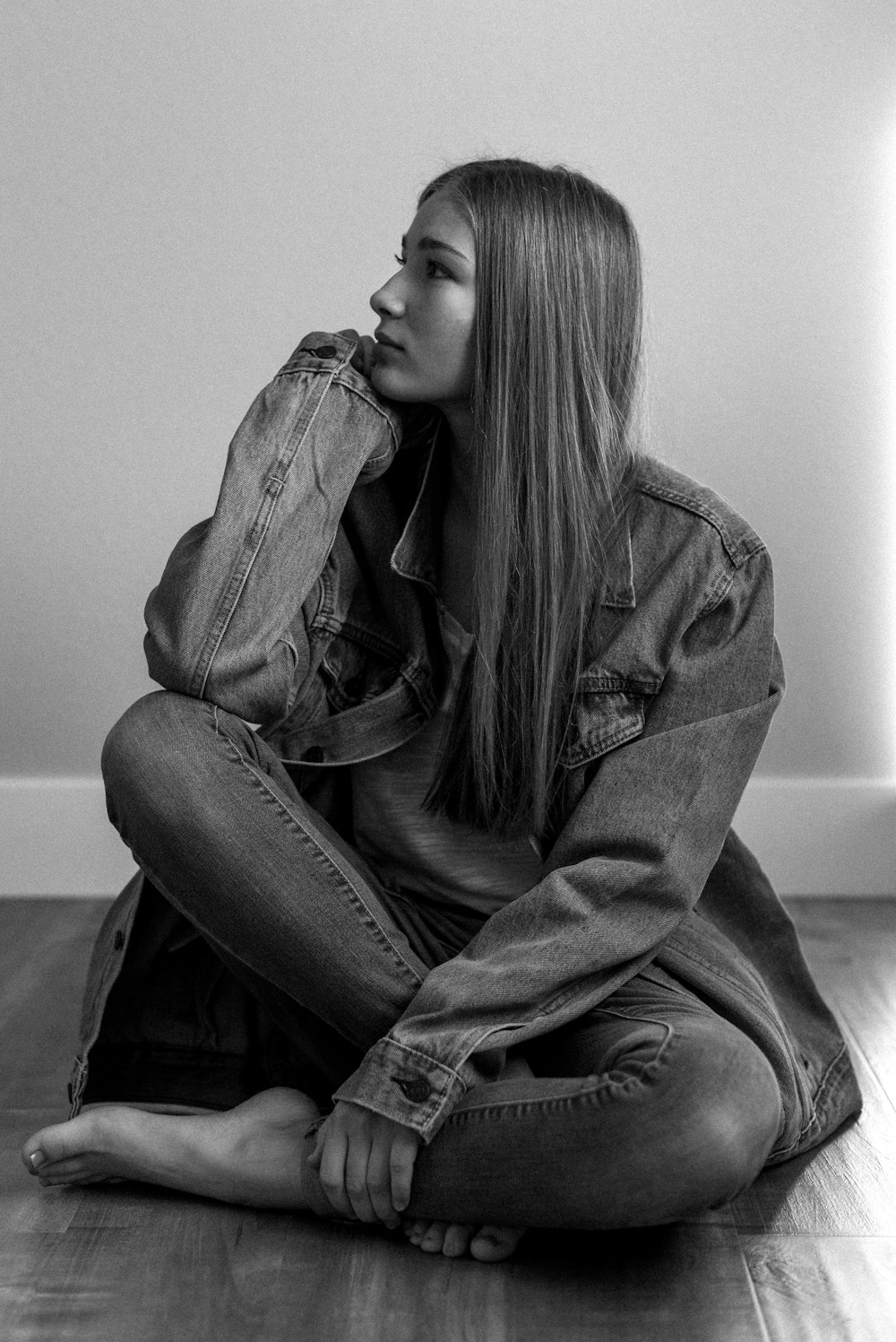 woman in denim jacket sitting on the floor