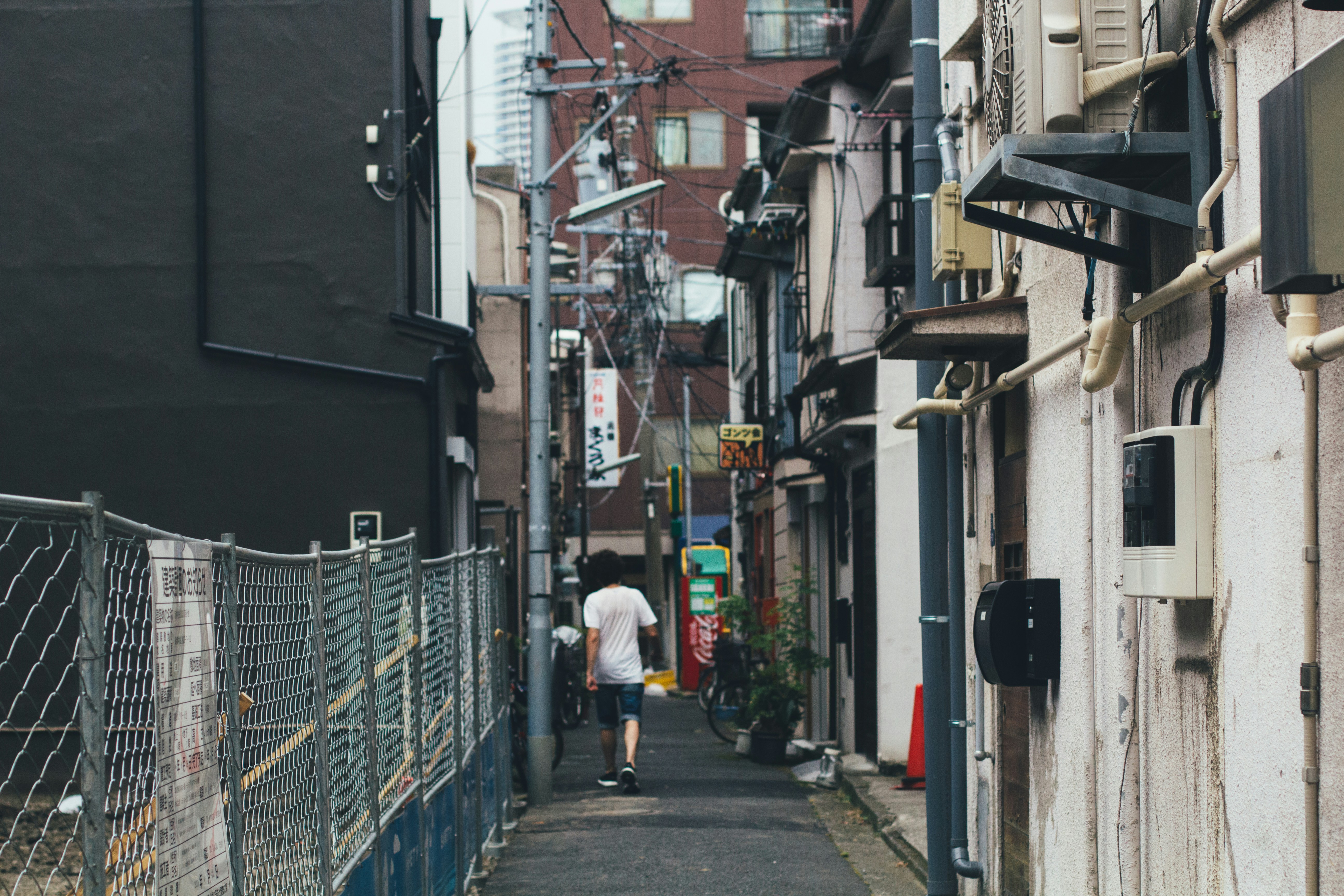 Homme marchant tranquillement sur un trottoir ensoleillé illustrant la vie quotidienne locale et respectueuse à Tokyo