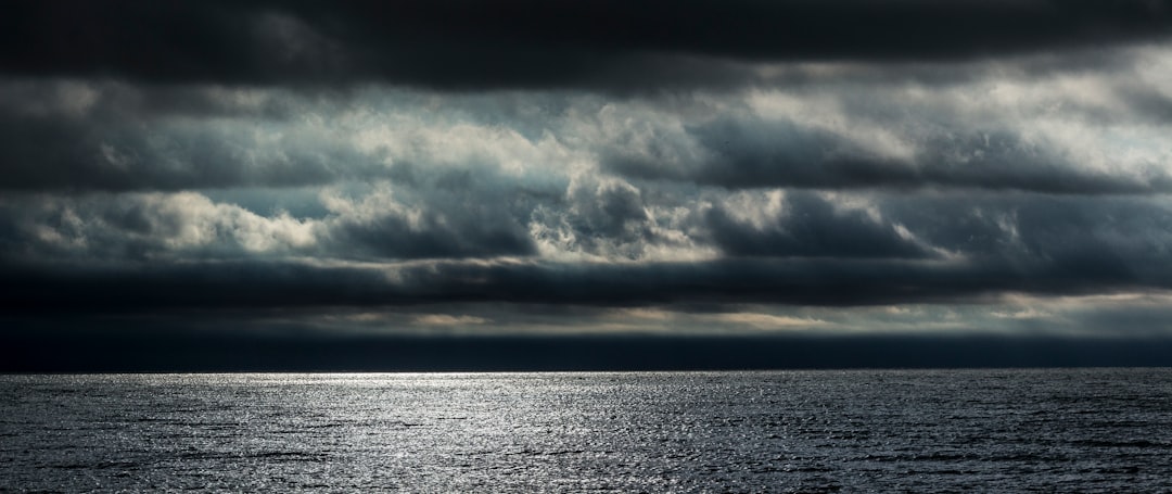 body of water under cloudy sky during daytime