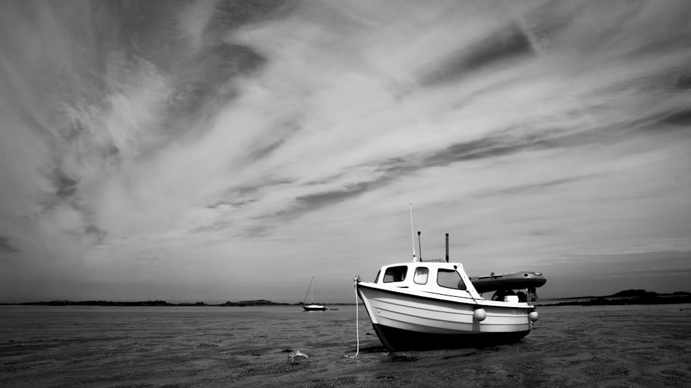 grayscale photo of boat on beach