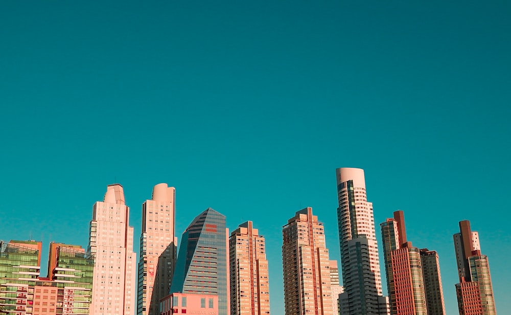 edifícios altos brancos e azuis sob o céu azul durante o dia