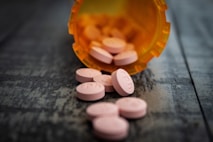 white medication pill on orange plastic container