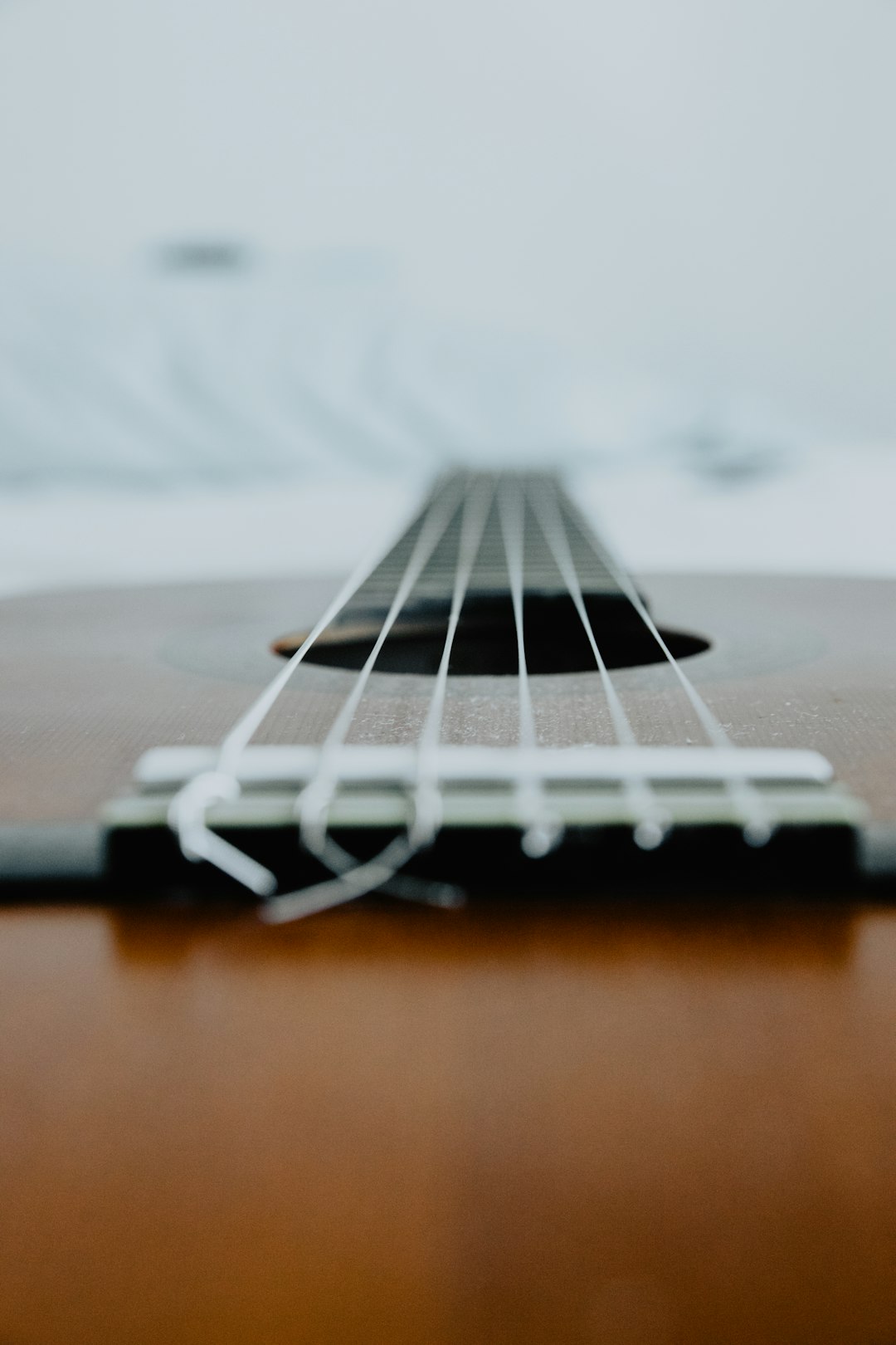 brown acoustic guitar on brown wooden table