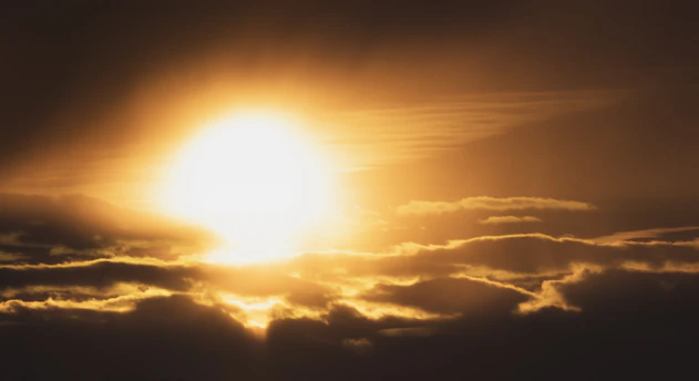 A sunrise breaking through dark clouds symbolizing hope and new beginnings.