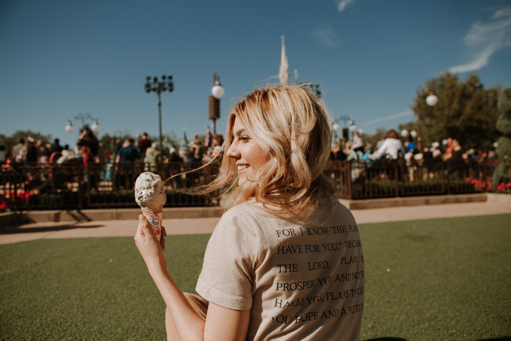 chica con camiseta blanca de cuello redondo sosteniendo cono de helado