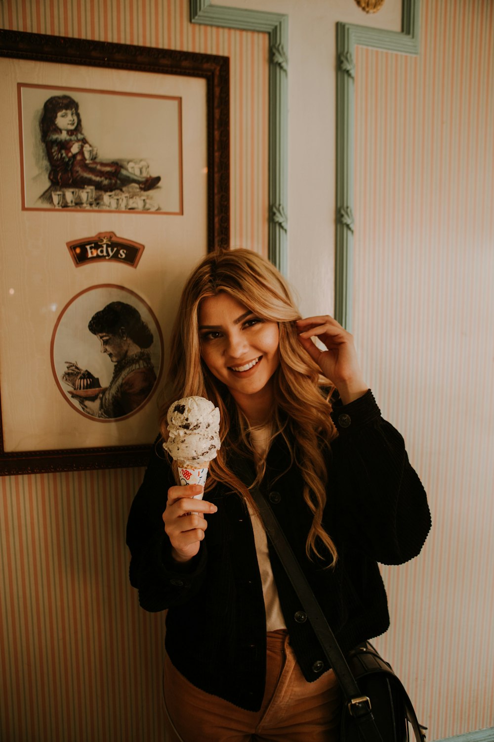 Mujer en chaqueta negra sosteniendo helado