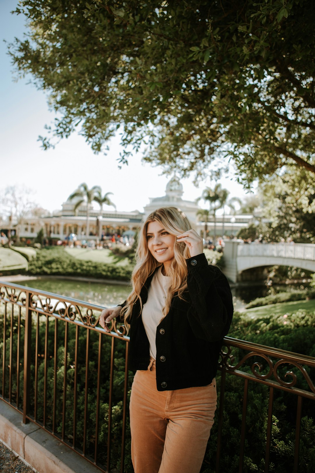 woman in black coat standing on bridge during daytime