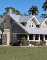 brown and white concrete house near green grass field during daytime