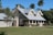 brown and white concrete house near green grass field during daytime