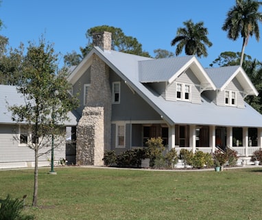 brown and white concrete house near green grass field during daytime