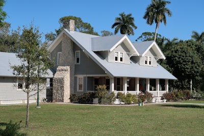 brown and white concrete house near green grass field during daytime