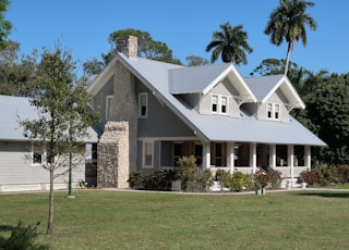 brown and white concrete house near green grass field during daytime