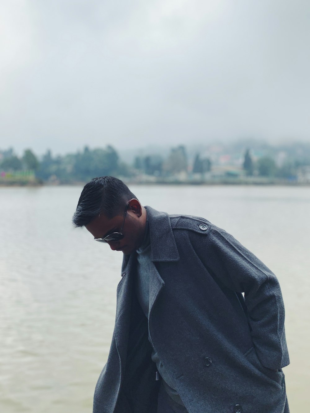 man in black coat standing near body of water during daytime