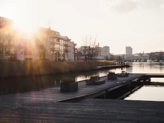 A sleek, modern waterfront apartment building bathed in golden sunset light.