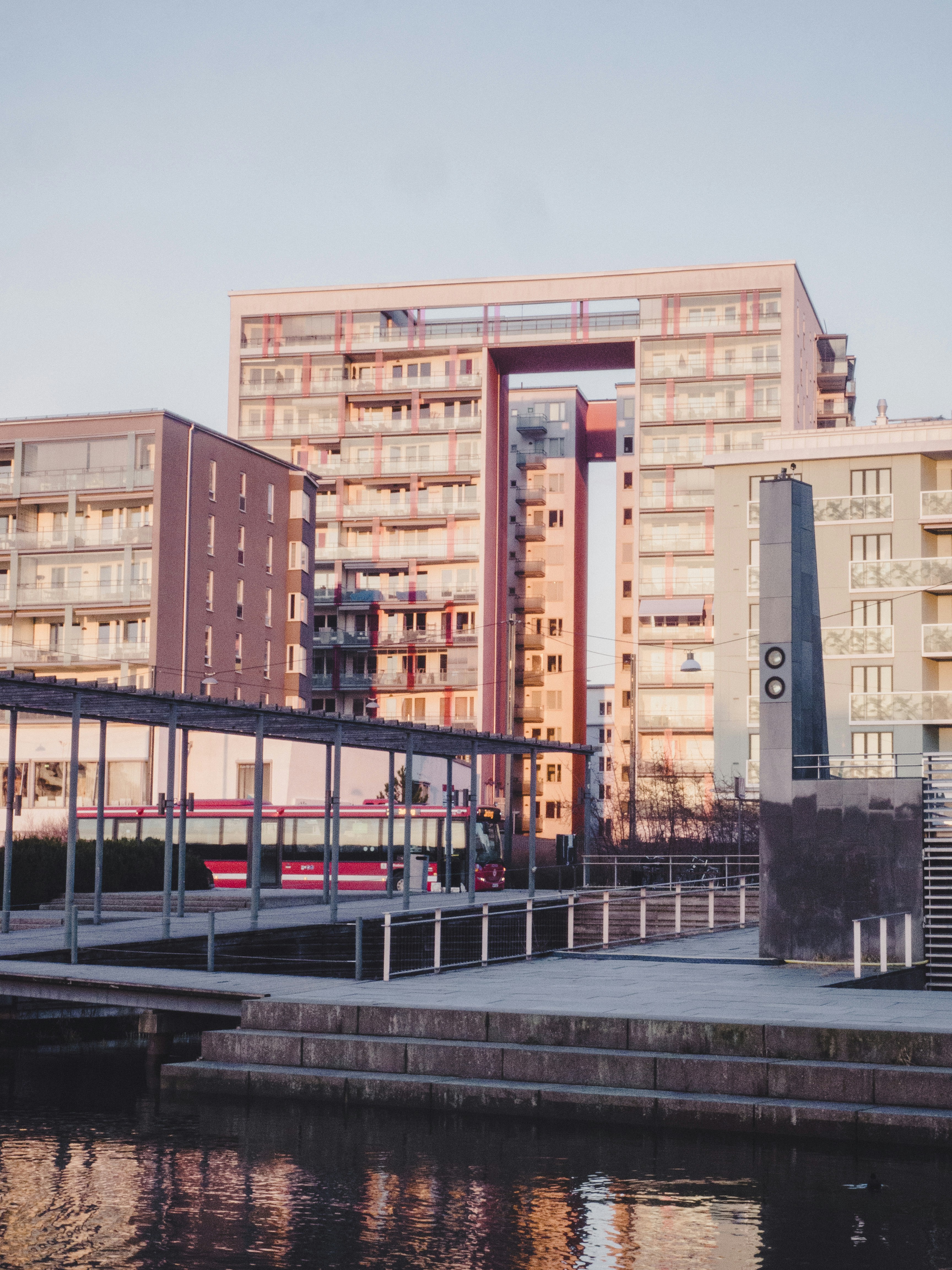 Edificio de hormigón marrón cerca de la valla metálica negra durante el día