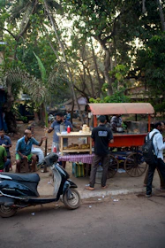 Happy customers enjoying freshly prepared snacks at an outdoor food cart.