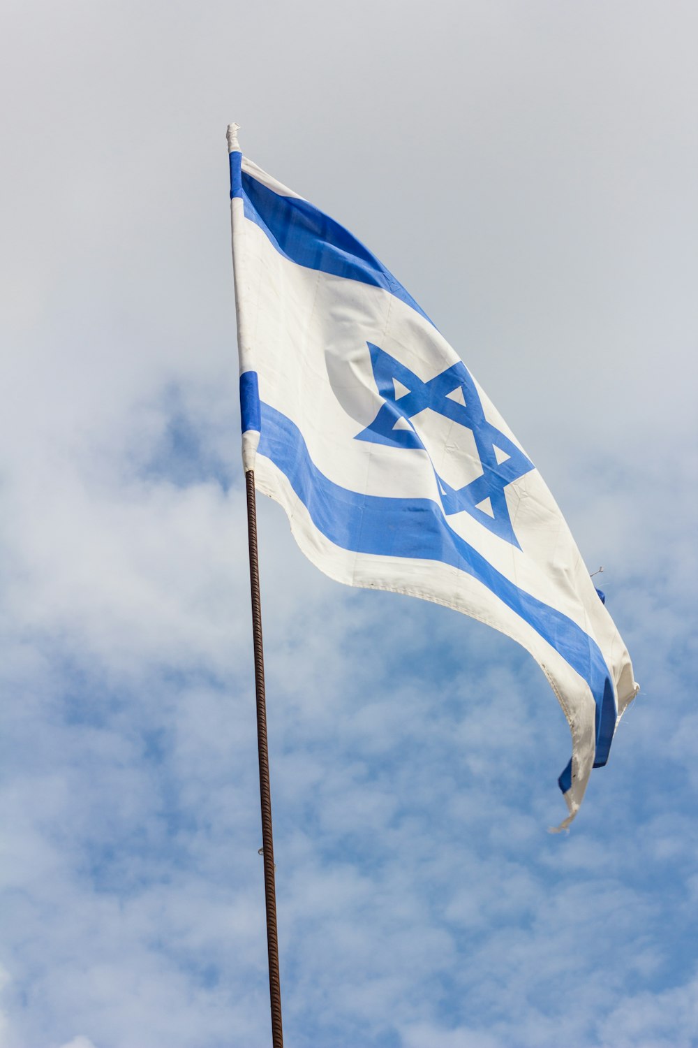 bandeira azul e branca sob o céu nublado durante o dia