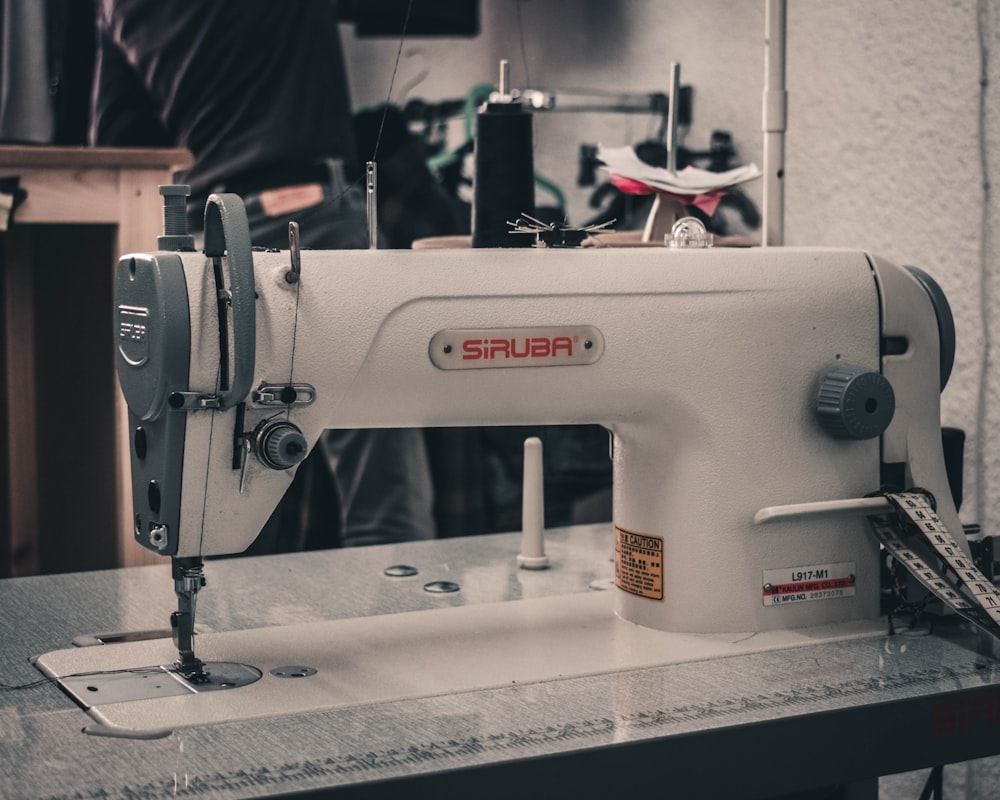 uma máquina de costura branca sentada em cima de uma mesa