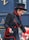 femme en veste de cuir noir et chapeau noir tenant un bâton rouge et blanc