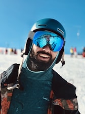 Close-up of a smiling customer gearing up for a snowmobile ride at Soo Outdoor Rentals.