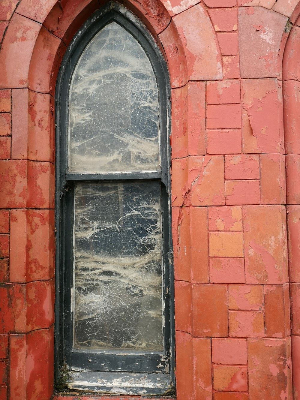 telaio della finestra in legno nero su muro di mattoni rossi