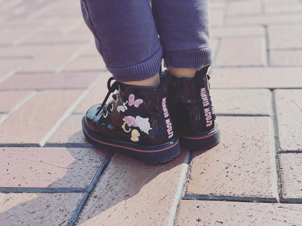 person in blue denim jeans and black and white converse all star high top sneakers