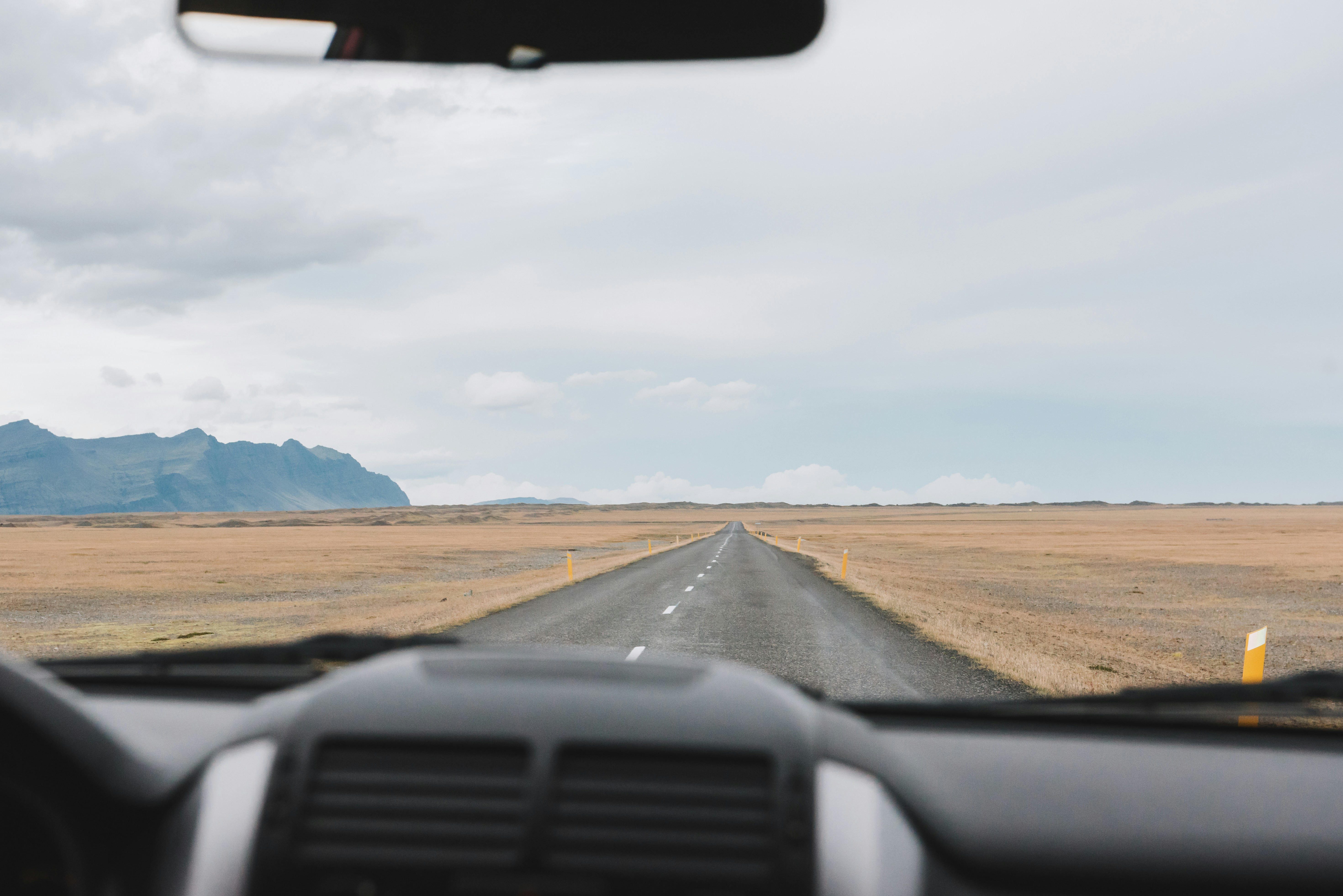 black car on desert during daytime, View of the long round ahead in Iceland, field, mountain and volcano and sky