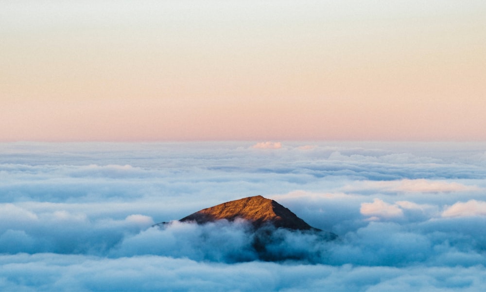 brown mountain under white clouds during daytime