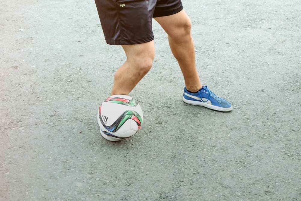 person in black shorts and blue and white nike soccer ball