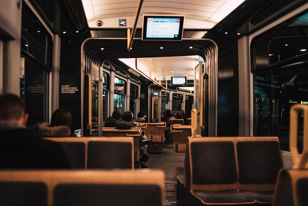 people sitting on brown chair inside train