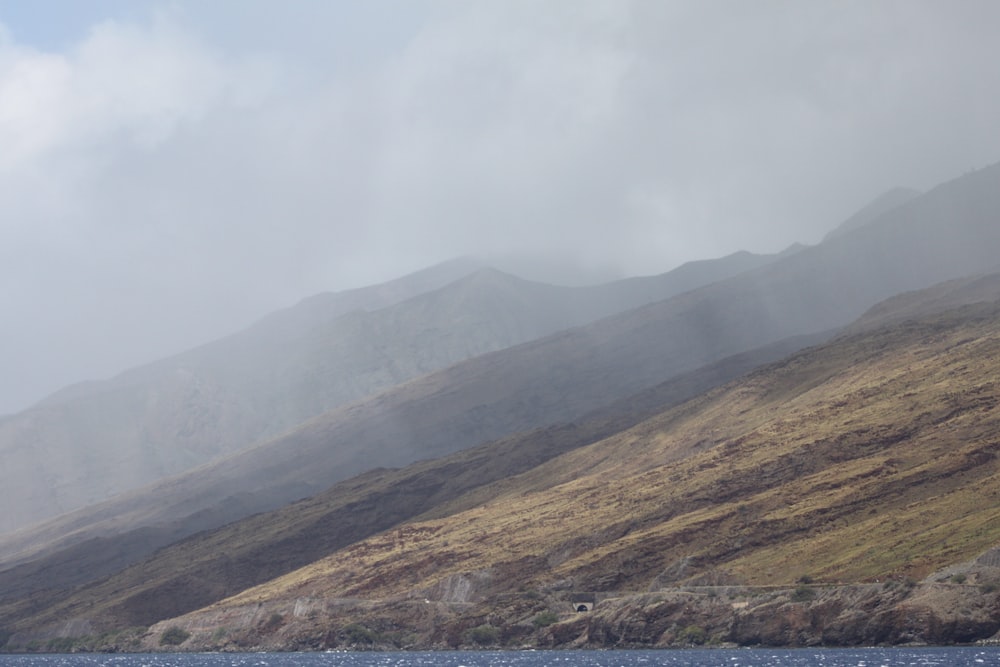 green and brown mountains under white clouds